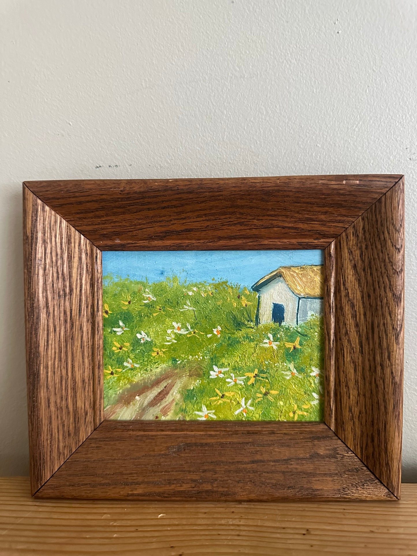 Framed field and cottage painting